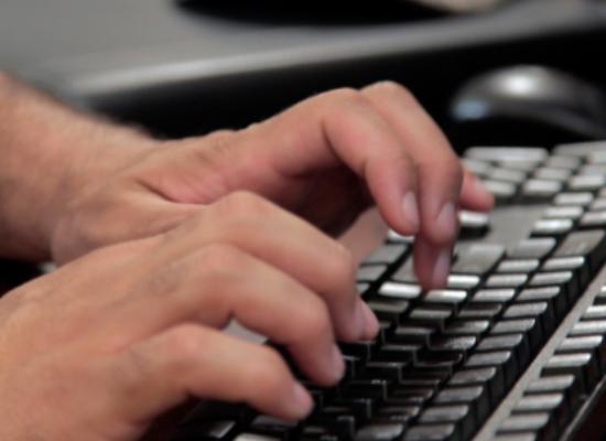 student typing on a keyboard